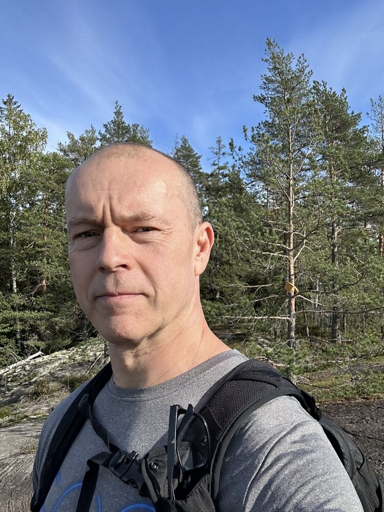 Päiväretkellä metsässä, taustalla mäntyjä ja sininen taivas
